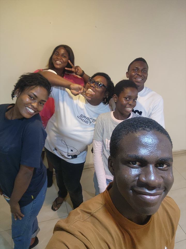 Osaro and Achi taking a joyful group selfie with loved ones