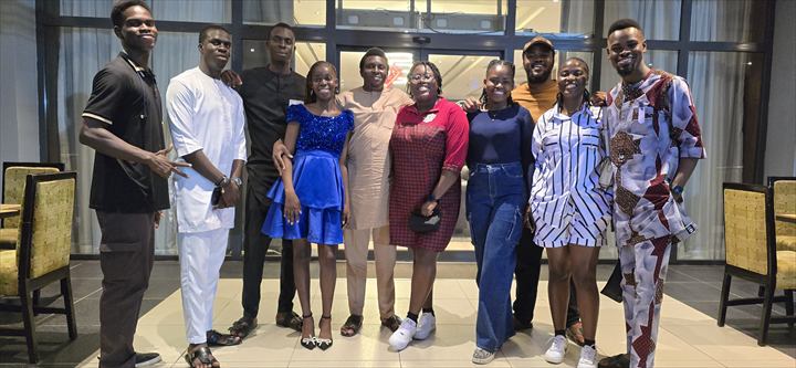 Osaro and Achi dressed for a celebration with a large group of loved ones
