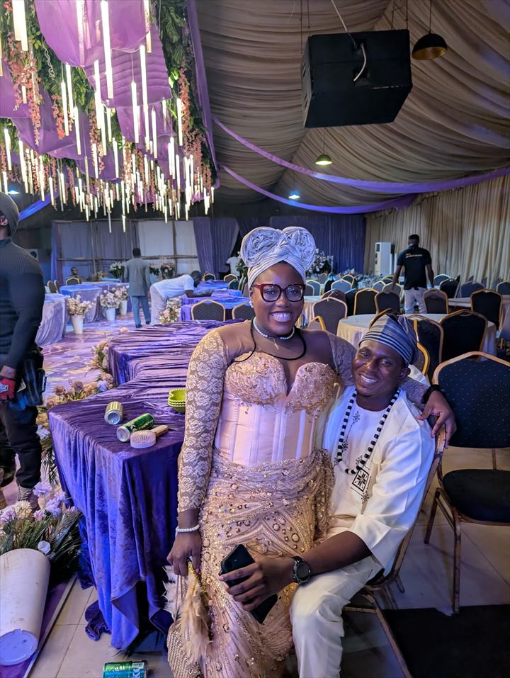 Osaro and Achi seated together at a beautifully decorated celebration